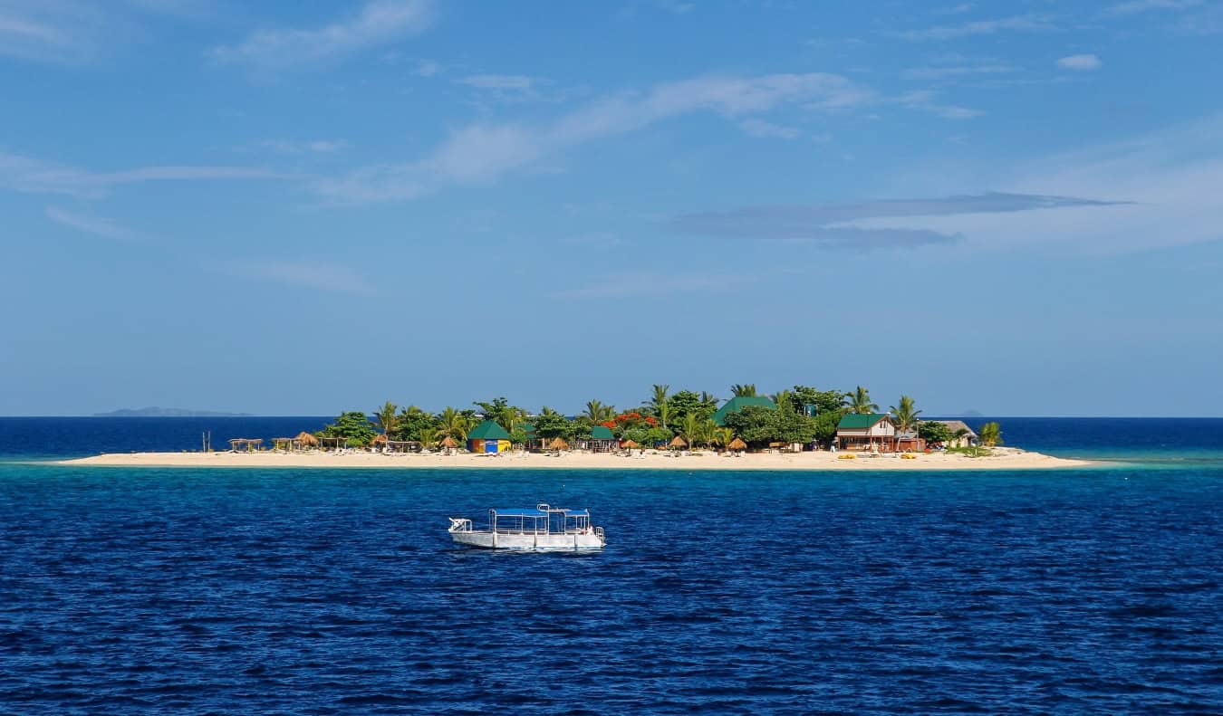 A boat floating off the shore in the Yasawa Islands in Fiji
