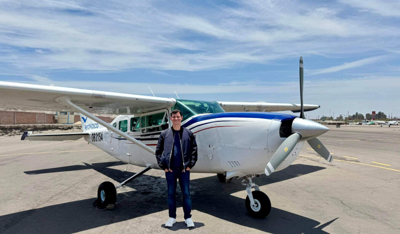 Nomadic Matt posing near a very small aircraft in Peru