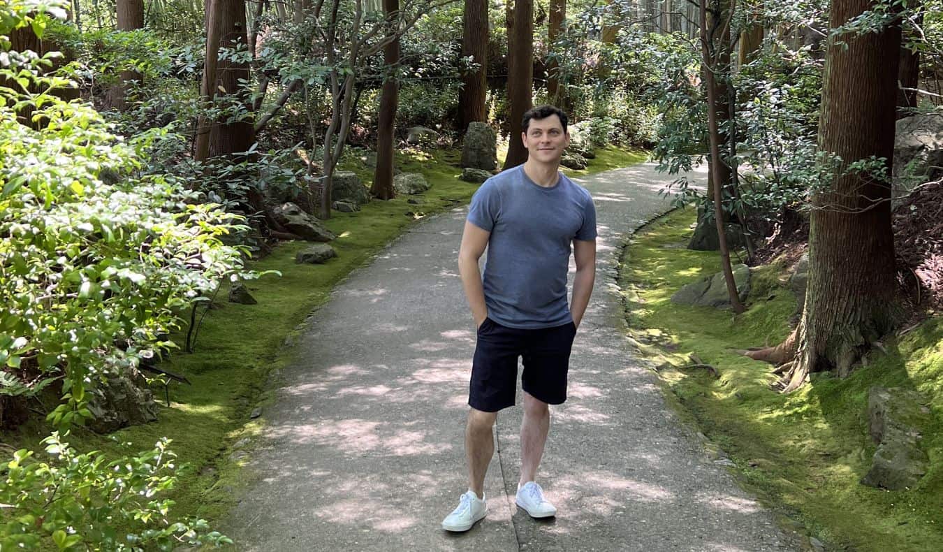 Nomadic Matt standing on a walking path in the forest