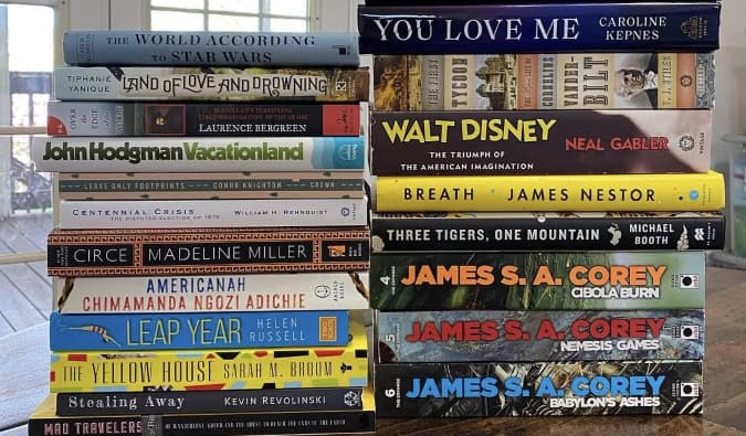 two stacks of Nomadic Matt's travel-related books